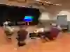 Een zaal met meerdere mensen in een ronde die aandachtig naar elkaar luisteren